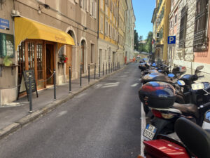 Via degli Artisti 11 dando le spalle alla Bora, con l'entrata dello "Snack bar Artisti", per per dove andare a mangiare a Trieste.